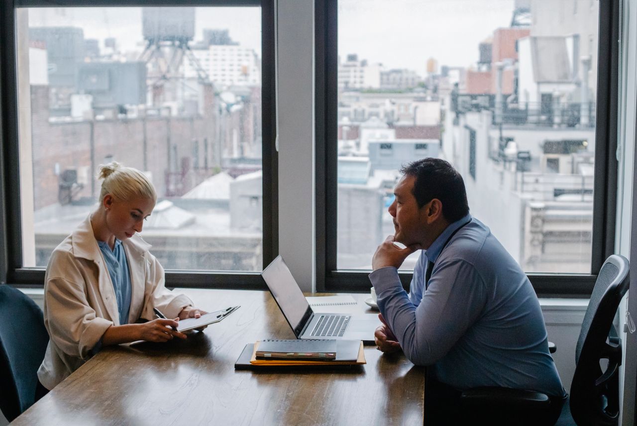 Business meeting between colleagues in a modern office setting with city view global talent finder